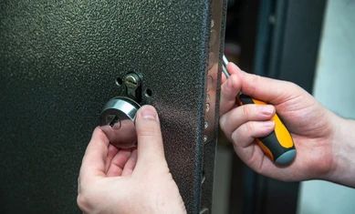 man-repairs-door-lock-closeup-260nw-1556222102.jpg